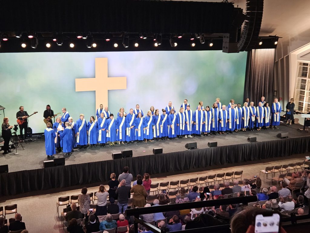 Nyss ordinerade diakoner och pastorer står på rad längst fram i Filadelfia Stockholm